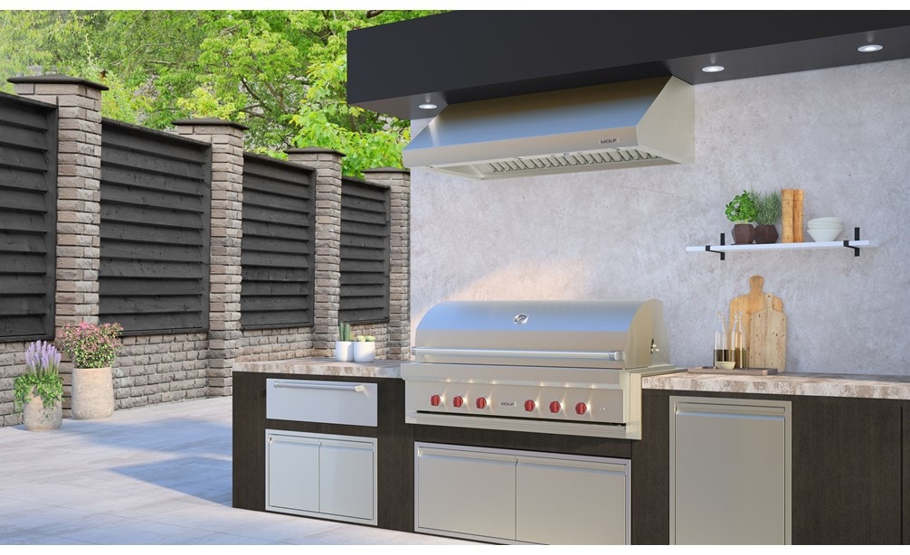 La parrilla de gas para exteriores de 54" Wolf (OG54) exhibida en una cocina de lujo para exteriores con electrodomésticos de cocina para exteriores de calidad profesional.