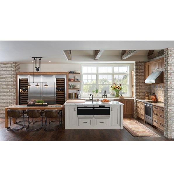 Horno microondas con puerta abatible transicional de 24" Wolf de la serie E (MDD24TE/S/TH) exhibido con una instalación al ras en una gran isla de cocina de granito personalizada