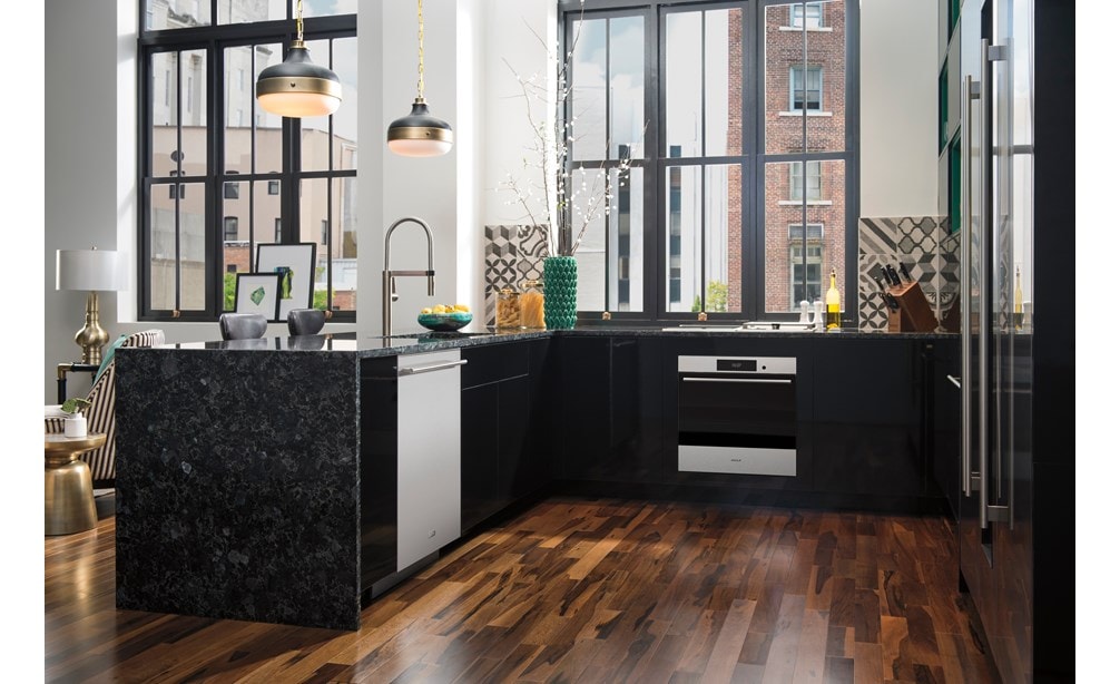 Horno individual empotrable transicional de la serie E de 24" Wolf (SO2450TE/S/T) debajo de los mostradores de granito azul Volga y sobre piso de nogal brasileño