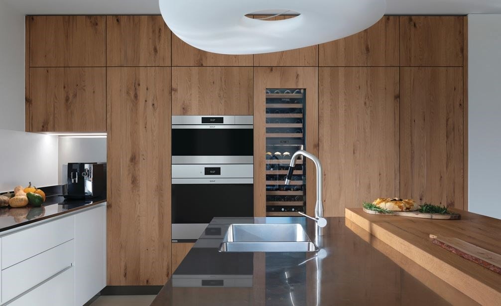 Horno de vapor contemporáneo de acero inoxidable de la serie M de 30" Wolf (CSO3050CM/S) exhibido en la pintoresca cocina suiza con gabinetes de madera ligera personalizados