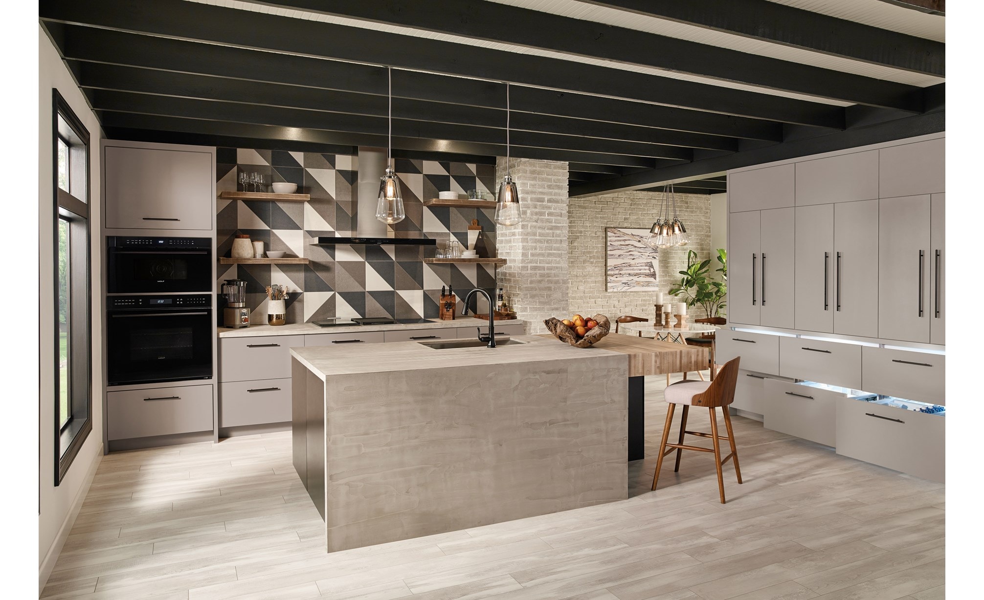 La campana extractora de placa de cocción de pared de 45" Wolf en negro (VW45B) exhibida en un diseño de cocina abierto ultramoderno y minimalista