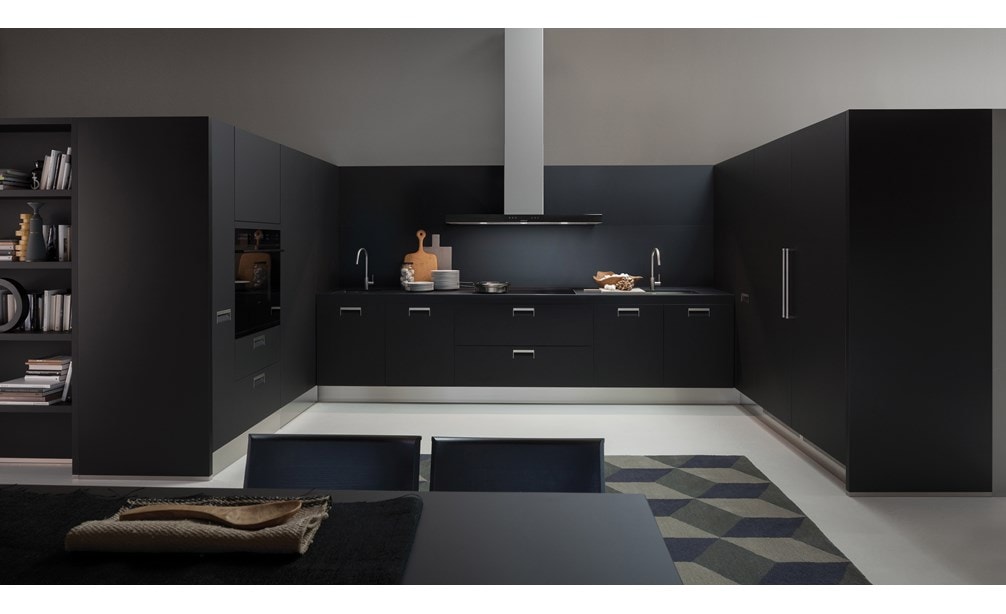 La campana extractora de placa de cocción de pared de 45" Wolf en negro (VW45B) exhibida en una integración elegante en un elegante diseño de habitación contemporáneo de tono oscuro.