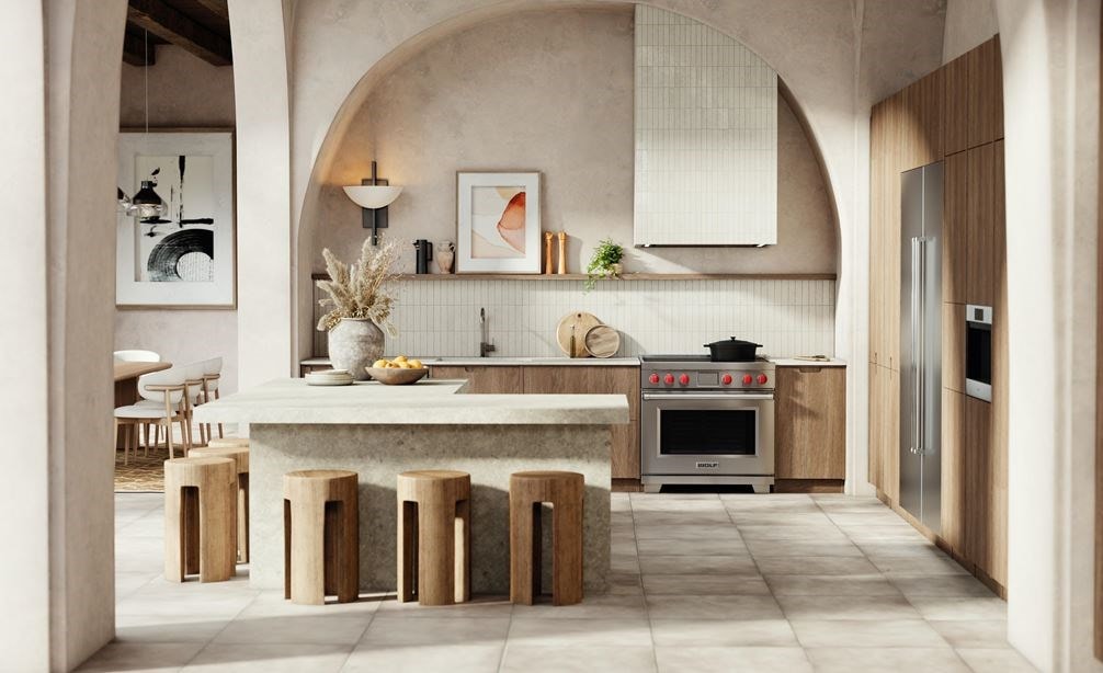 Wolf Professional Induction Range with iconic red knobs shown in a modern bohemian kitchen design featuring an arcade of tall arch walls with matching l-shaped kitchen island.